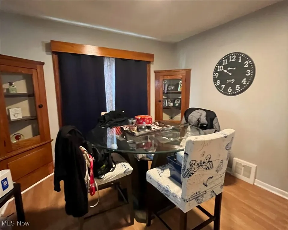 Dining area featuring baseboards, visible vents, and wood finished floors