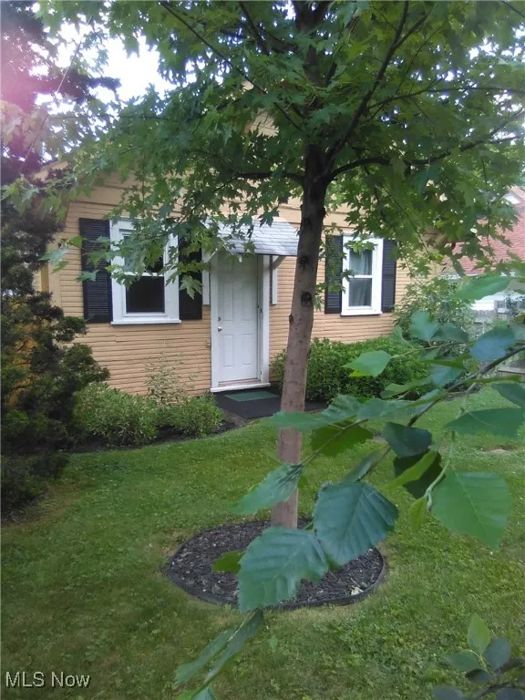 Doorway to property with a lawn