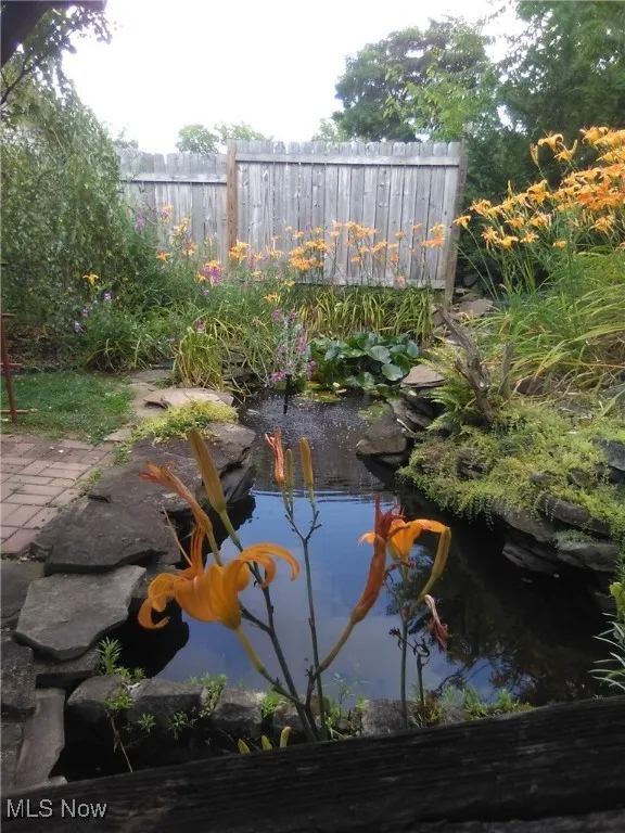View of pool with a small pond