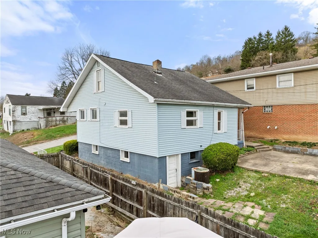 Rear view of property with fence, a chimney, a patio, and roof with shingles