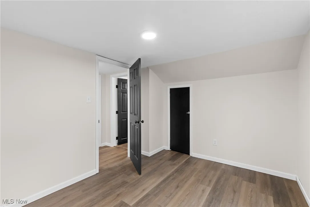 Unfurnished bedroom with baseboards and wood finished floors