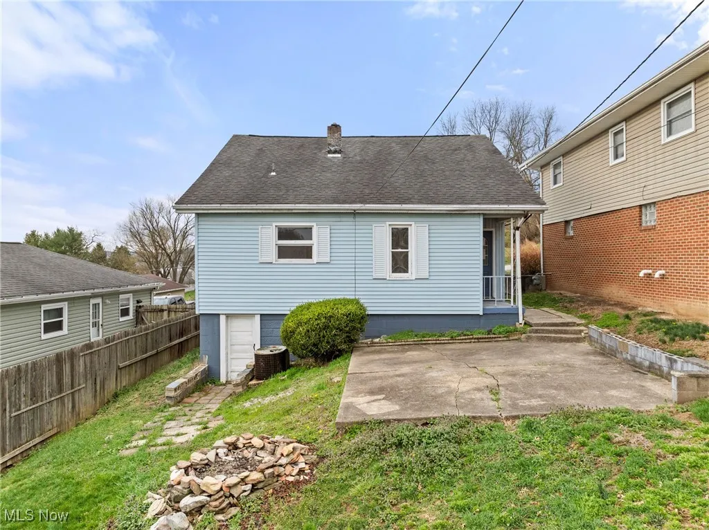 Back of property featuring central air condition unit, fence, a patio area, a yard, and a chimney