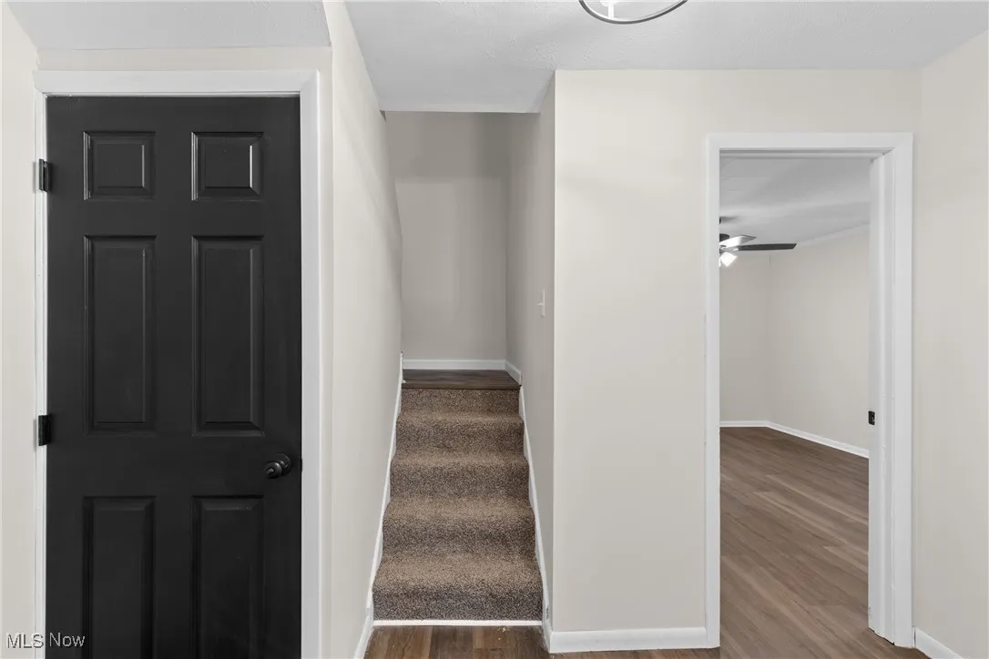 Stairs featuring baseboards, ceiling fan, and wood finished floors