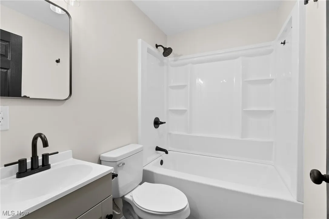 Bathroom with toilet, vanity, and shower / bathtub combination