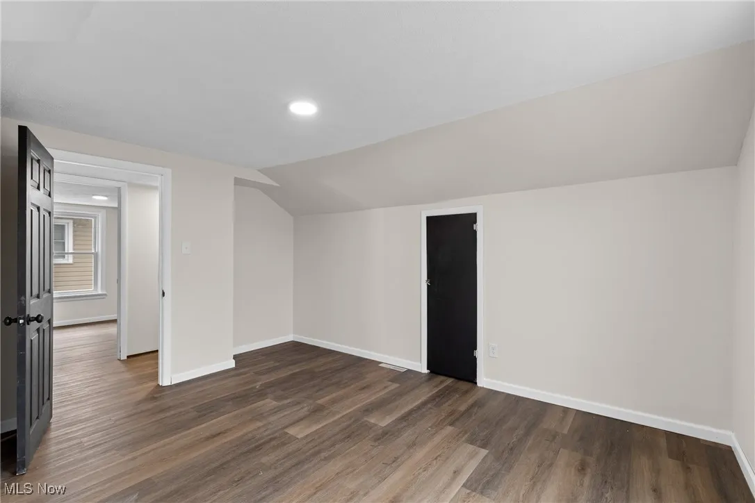 Bonus room with baseboards, lofted ceiling, recessed lighting, and dark wood-type flooring