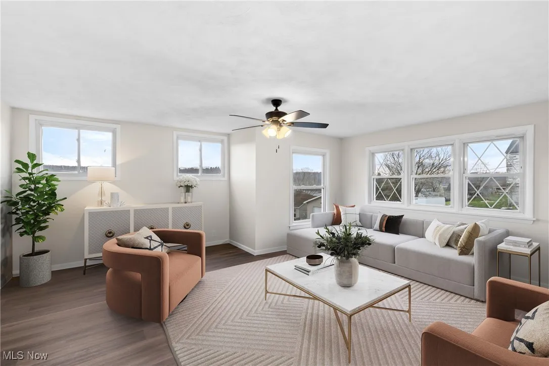 Living area with baseboards, ceiling fan, and wood finished floors