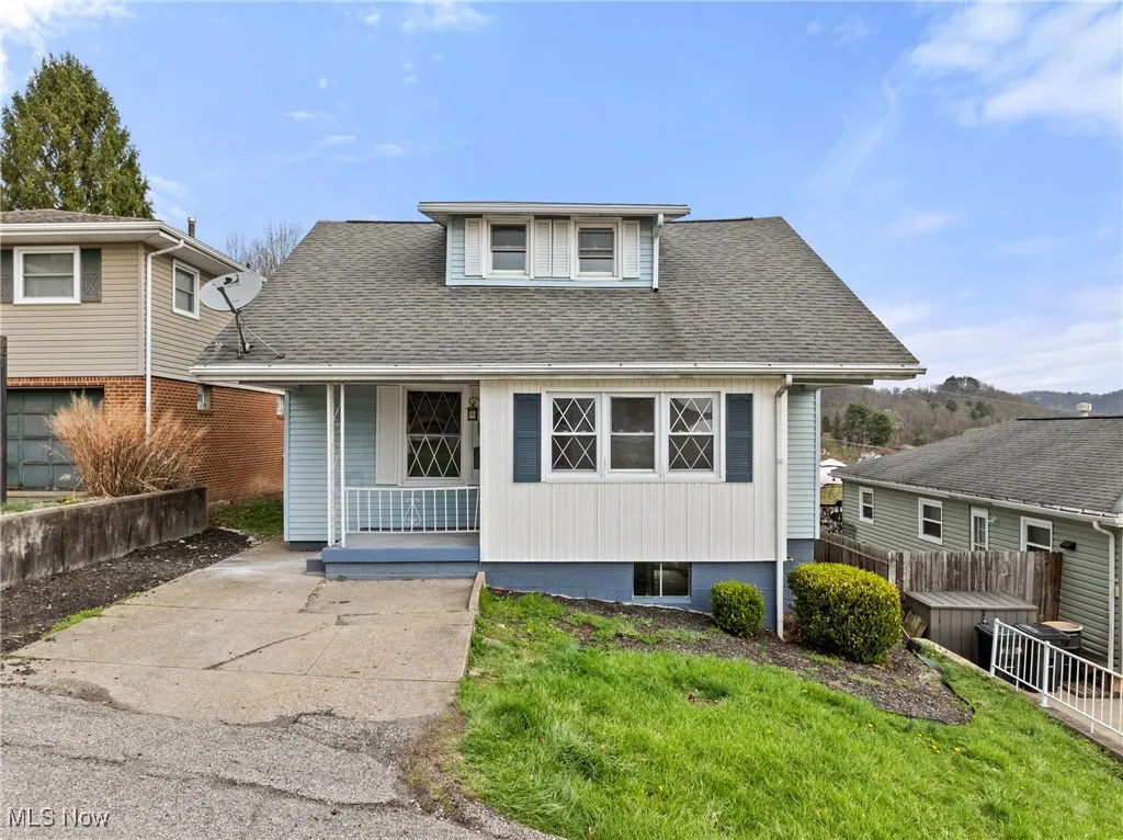 Bungalow-style home with a shingled roof, fence, a front lawn, and a porch