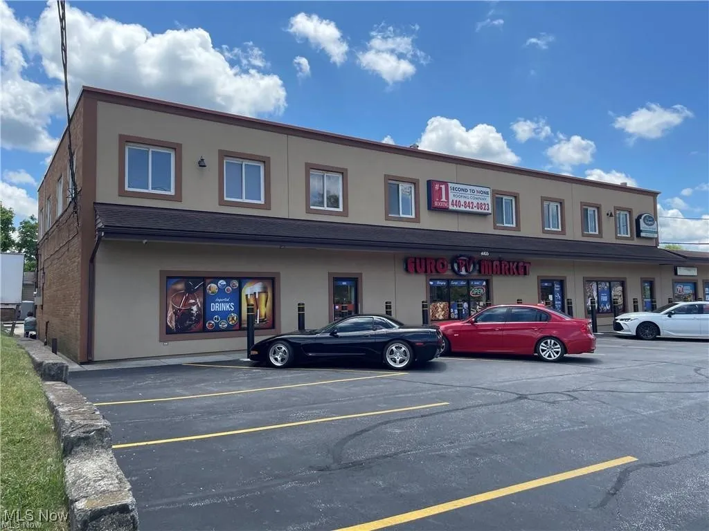 View of building exterior with uncovered parking