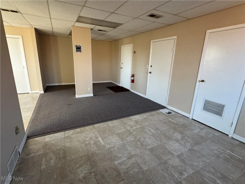 Unfurnished room with a drop ceiling, baseboards, and visible vents