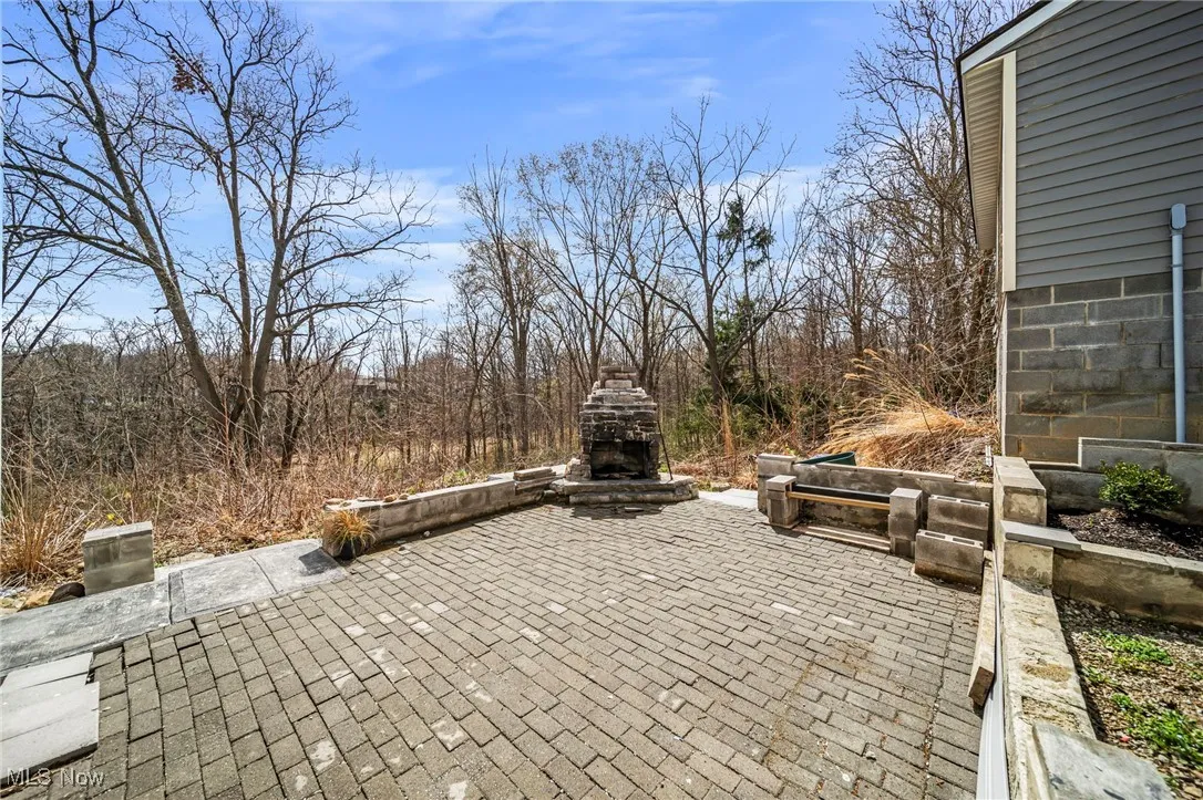 View of patio with an outdoor stone fireplace