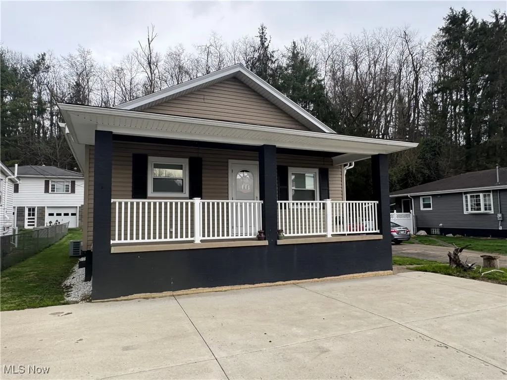 View of front of property featuring covered porch and fence