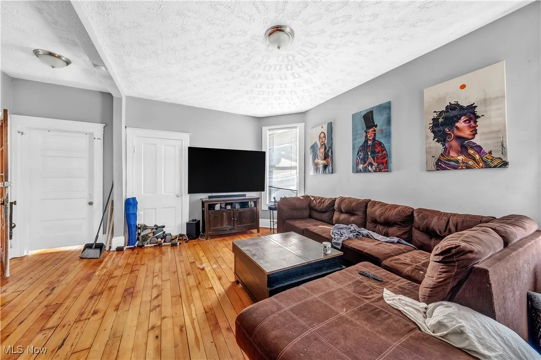 Living room featuring light wood-style flooring and a textured ceiling