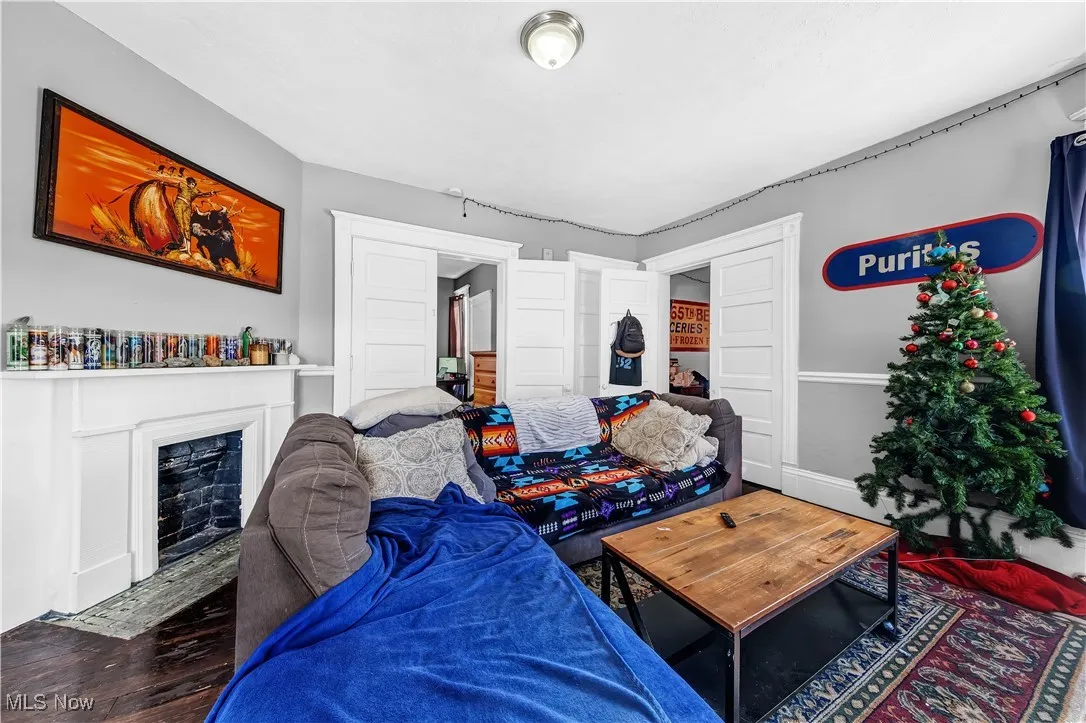 Living area with a fireplace with flush hearth and wood finished floors