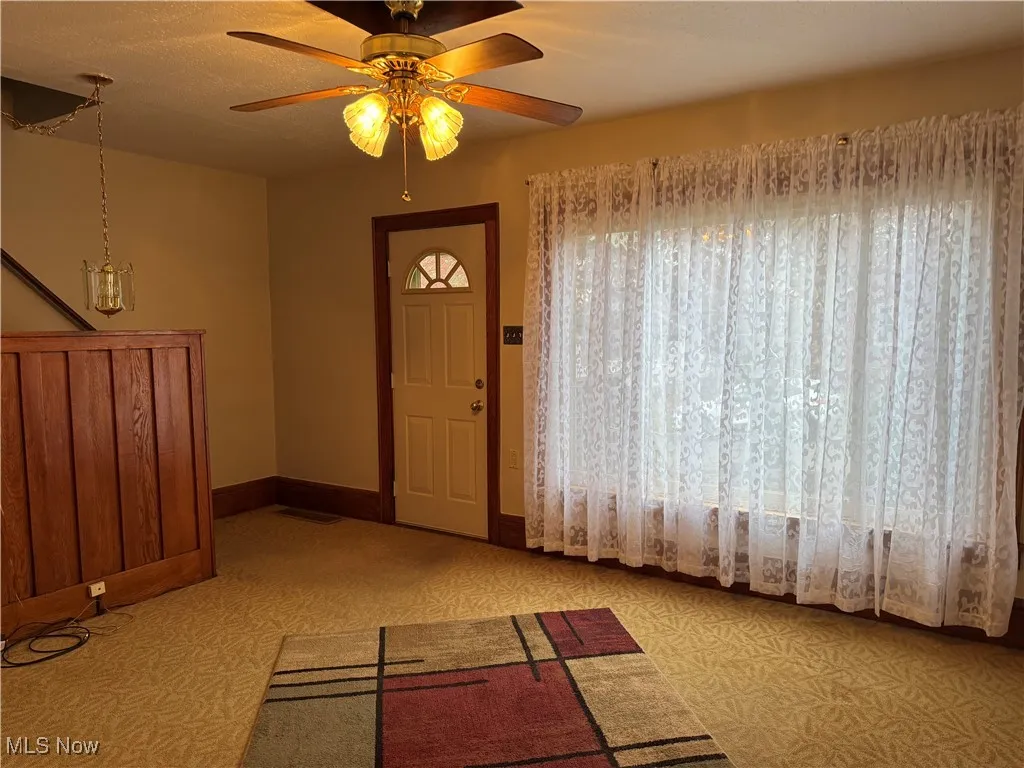 Entryway with baseboards and a ceiling fan