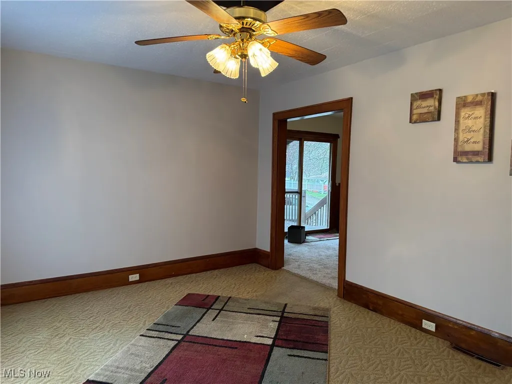 Spare room featuring baseboards, a ceiling fan, visible vents, and carpet