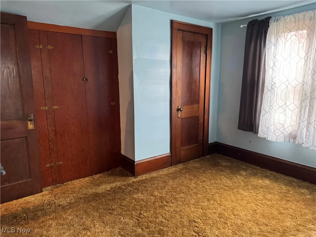 Unfurnished bedroom featuring baseboards and carpet flooring