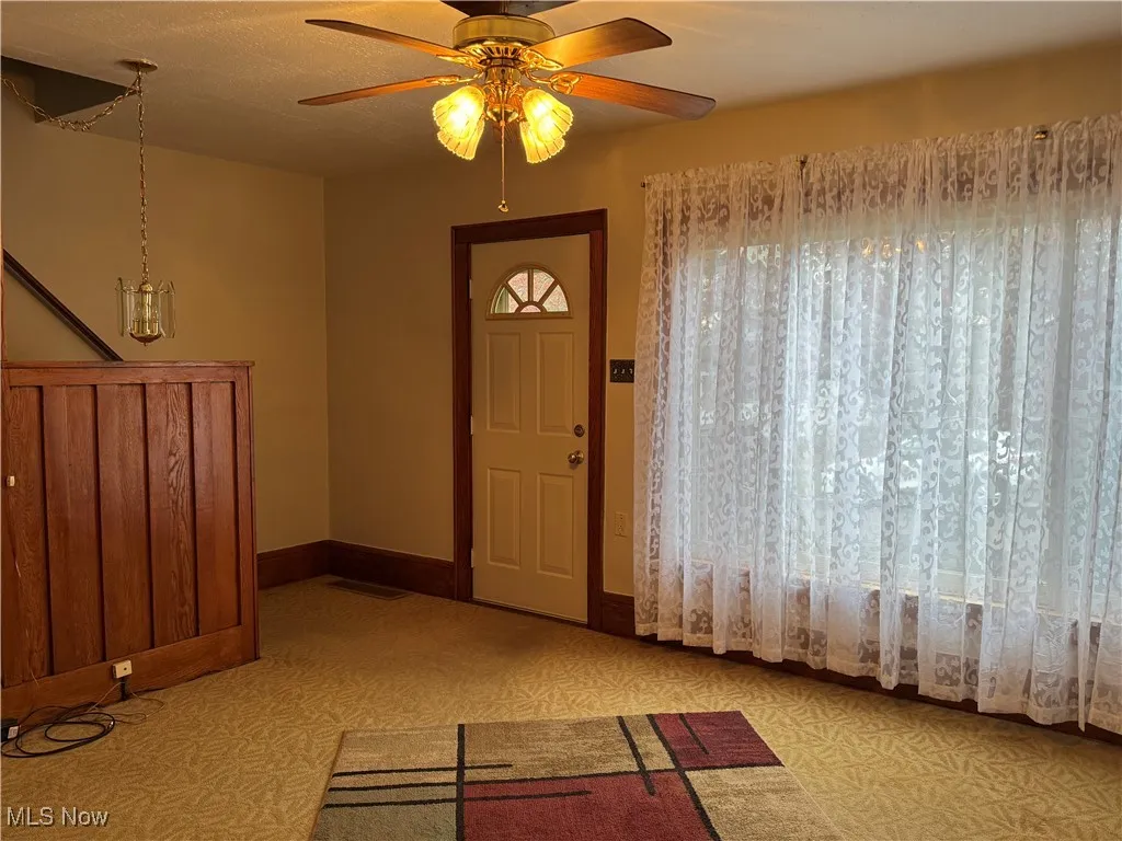 Entryway with baseboards and a ceiling fan