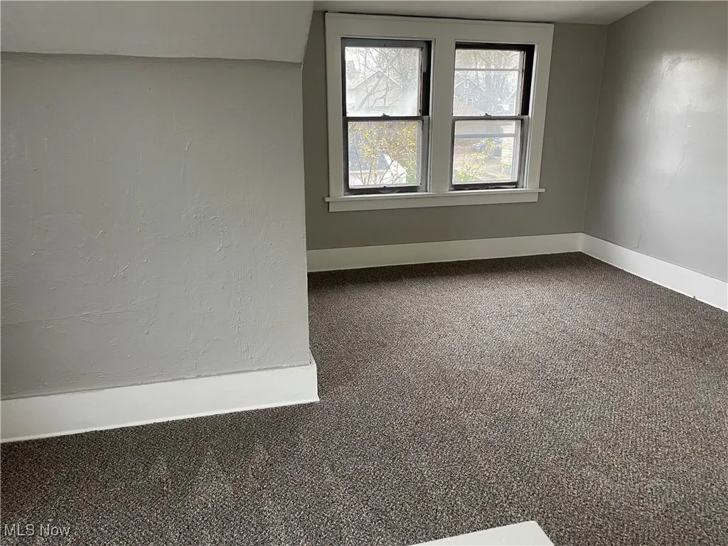 Empty room featuring carpet flooring and baseboards
