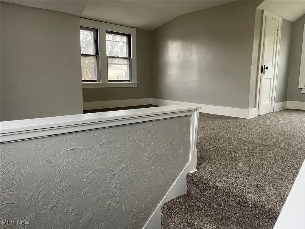 Staircase featuring carpet flooring, baseboards, and vaulted ceiling