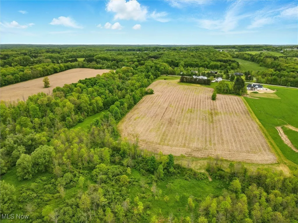 View of rural area with a heavily wooded area and farmland