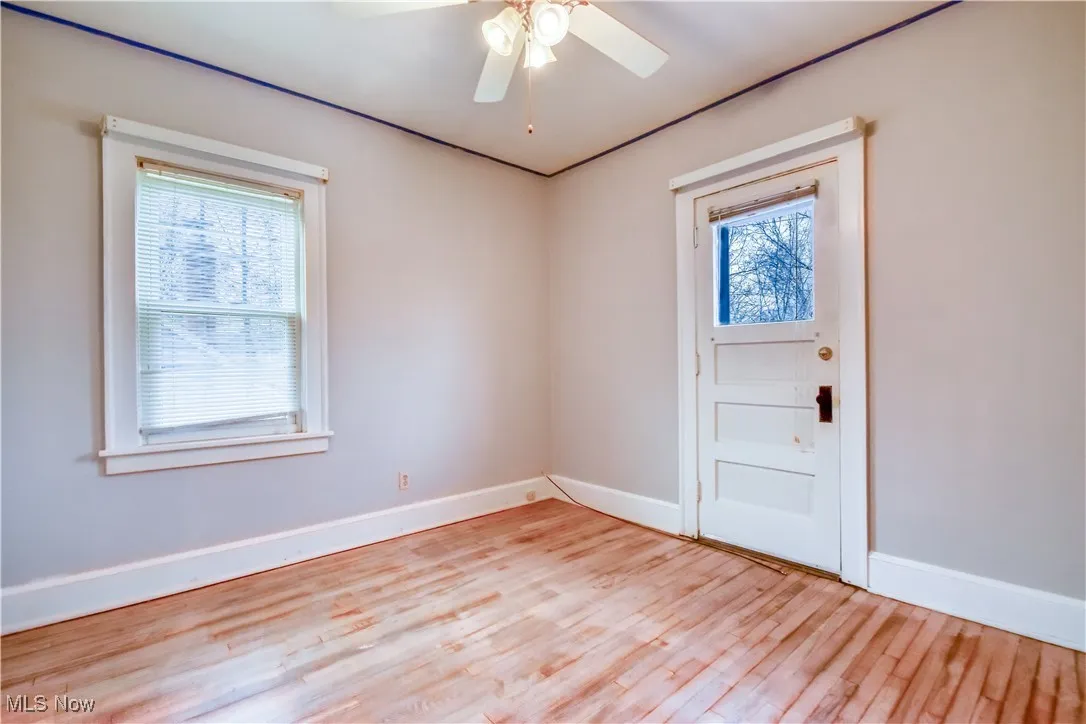 Foyer entrance featuring baseboards, ceiling fan, and light wood-style flooring