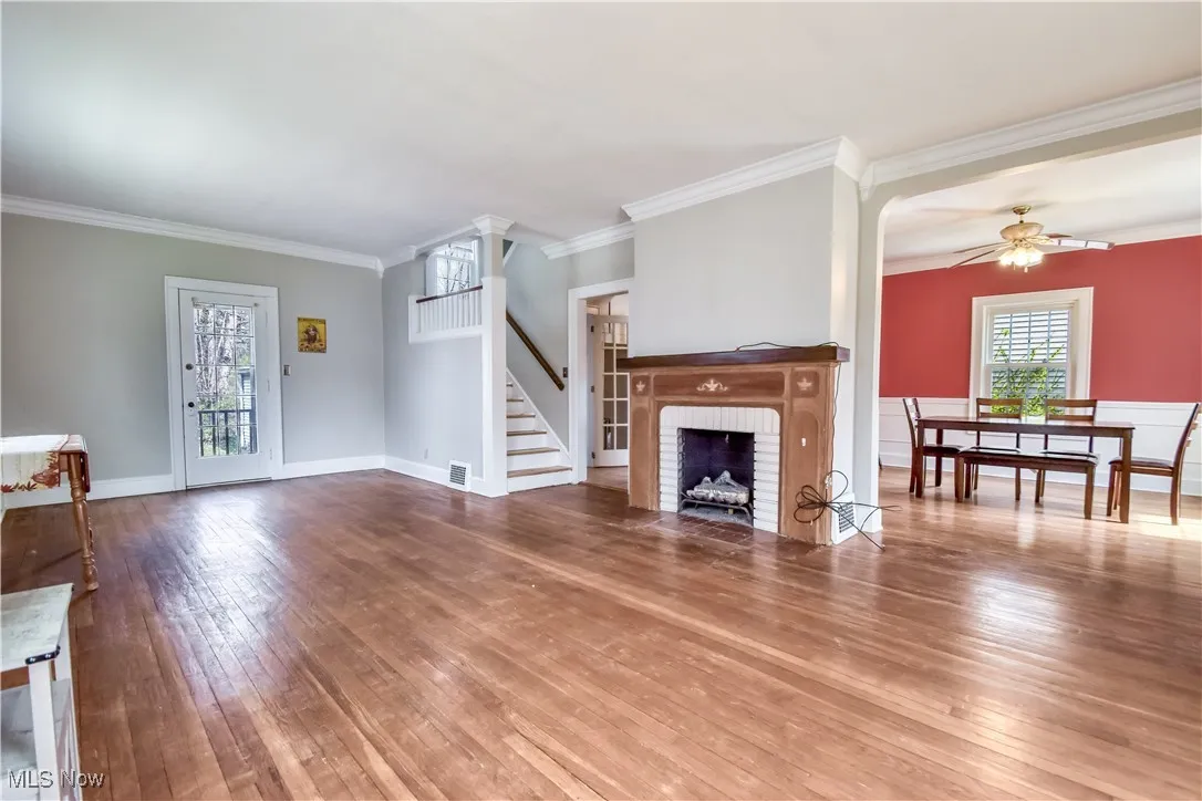 Unfurnished living room featuring wood-type flooring, visible vents, ceiling fan, and a healthy amount of sunlight