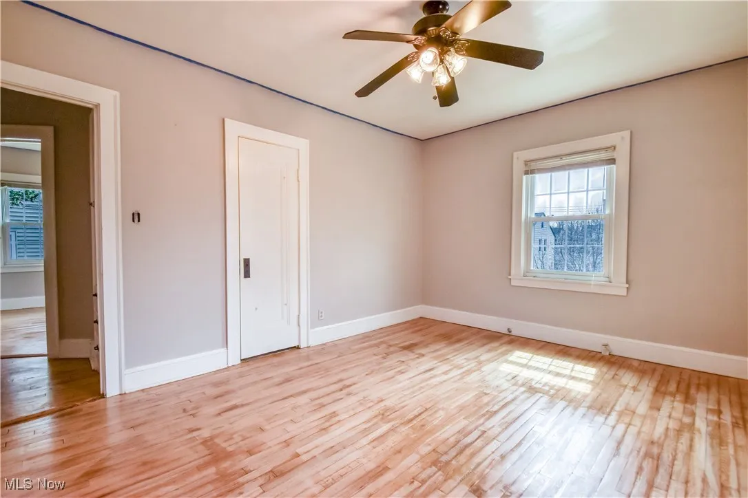 Unfurnished room featuring baseboards, ceiling fan, and light wood-style flooring