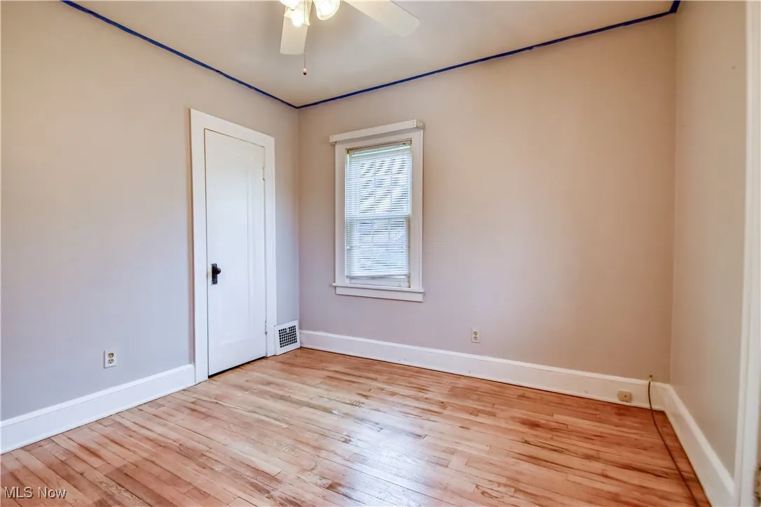 Unfurnished room with a ceiling fan, baseboards, light wood finished floors, and visible vents