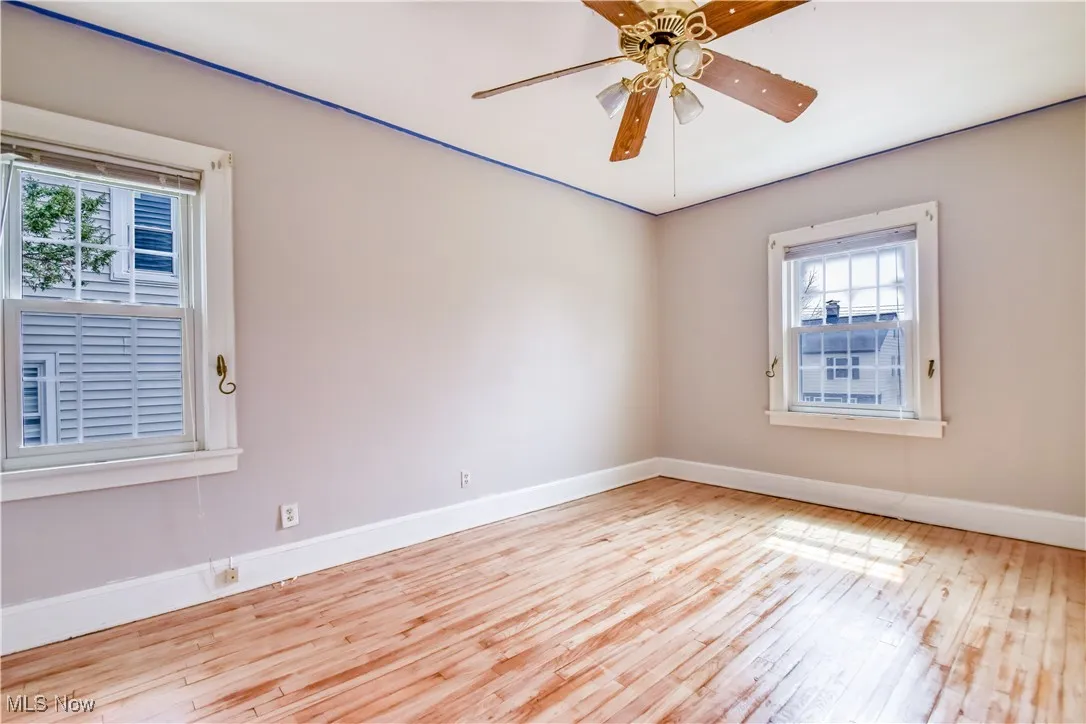 Unfurnished room with baseboards, ceiling fan, and hardwood / wood-style flooring