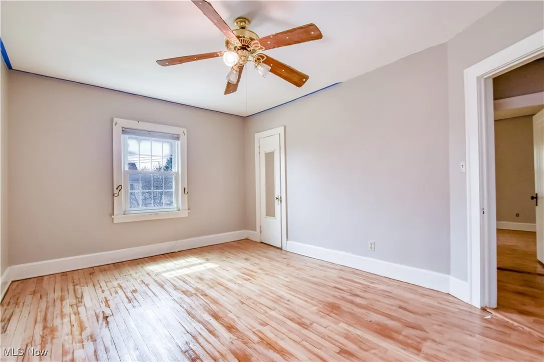 Spare room featuring baseboards, light wood-style floors, and ceiling fan