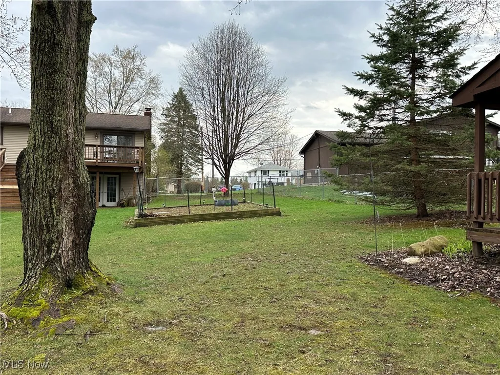 View of yard featuring fence and a wooden deck