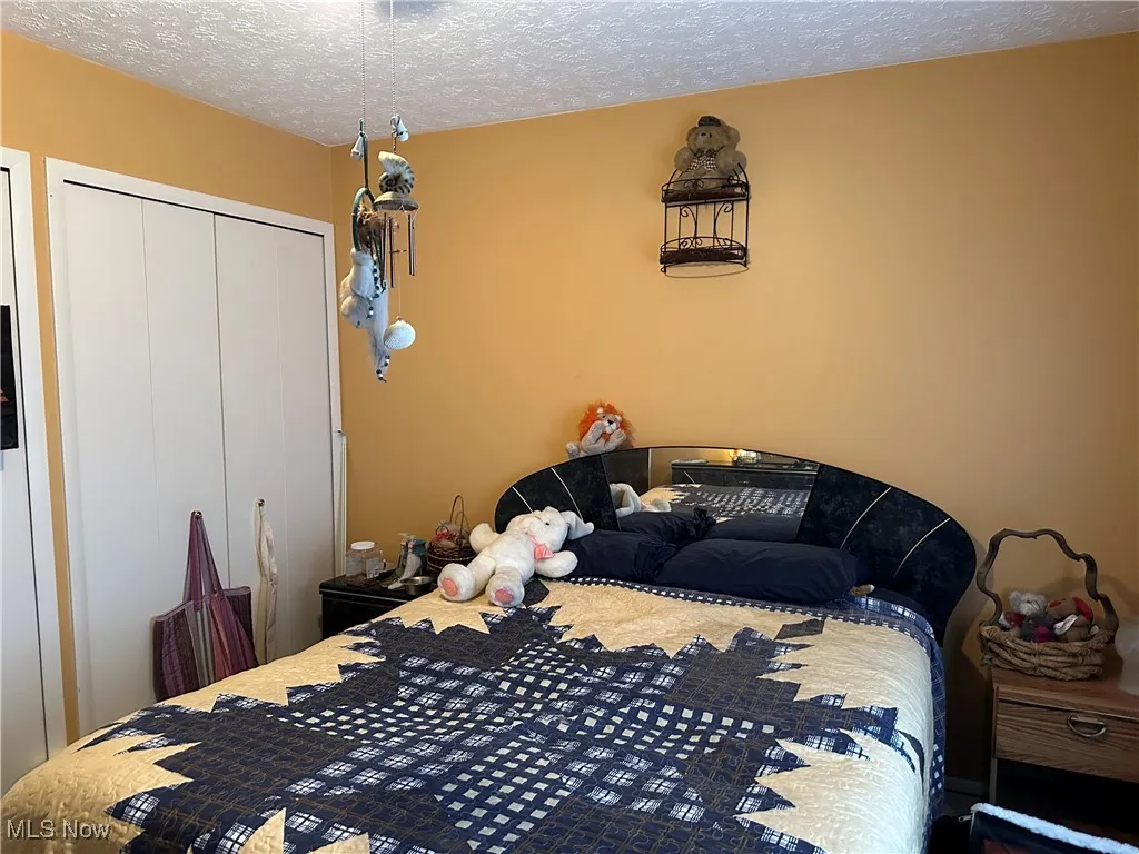 Bedroom featuring a closet and a textured ceiling