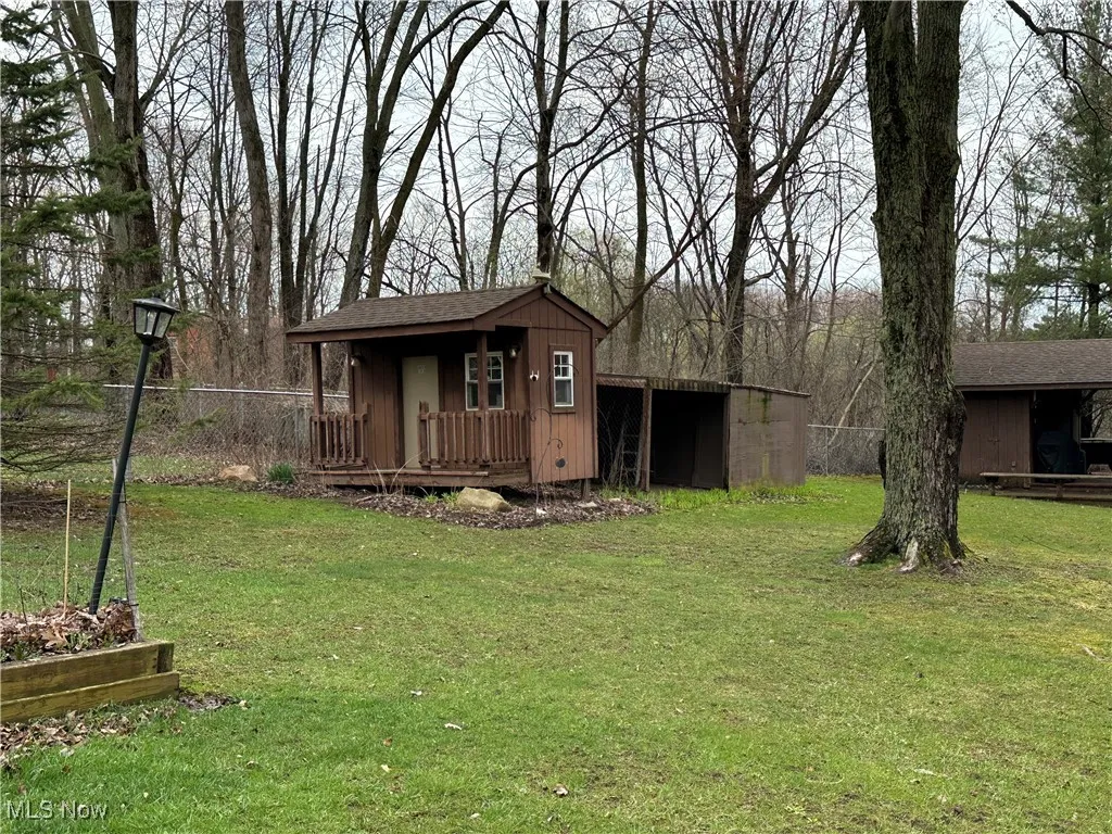View of outbuilding with an outdoor structure and fence