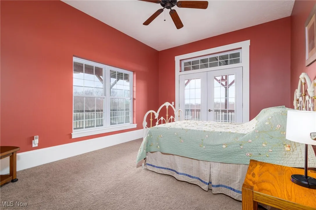 Carpeted bedroom featuring access to outside, ceiling fan, and french doors