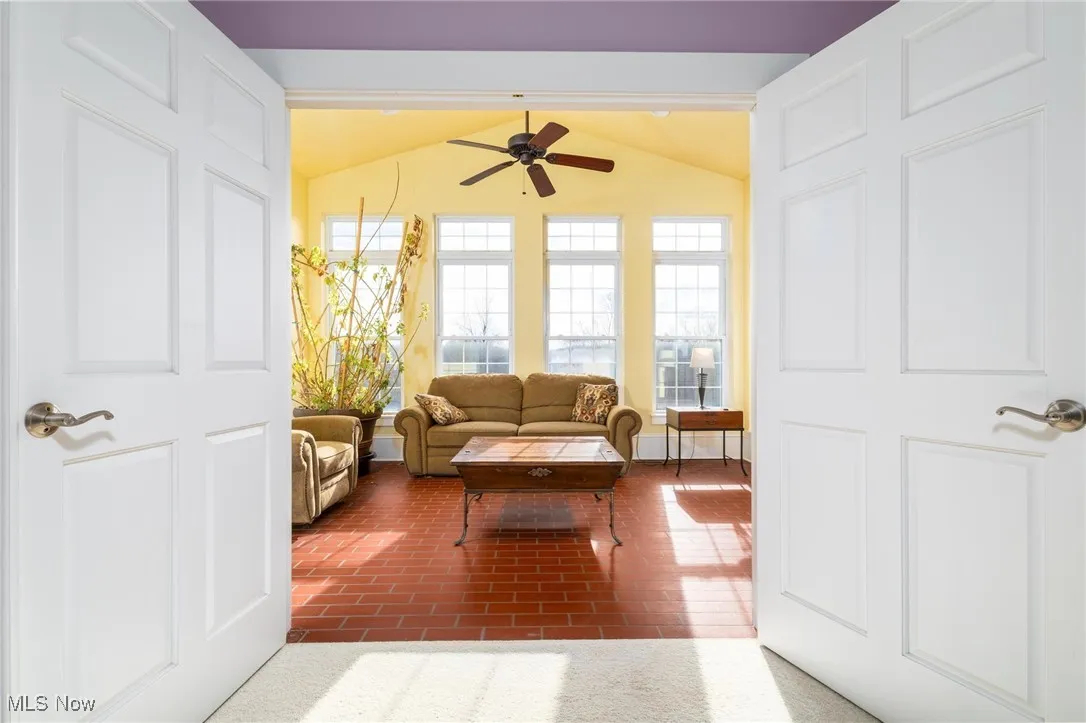 Living room featuring lofted ceiling and ceiling fan