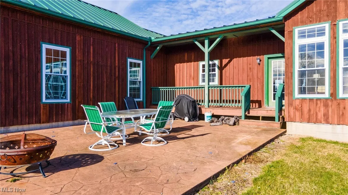View of patio with a fire pit and a wooden deck