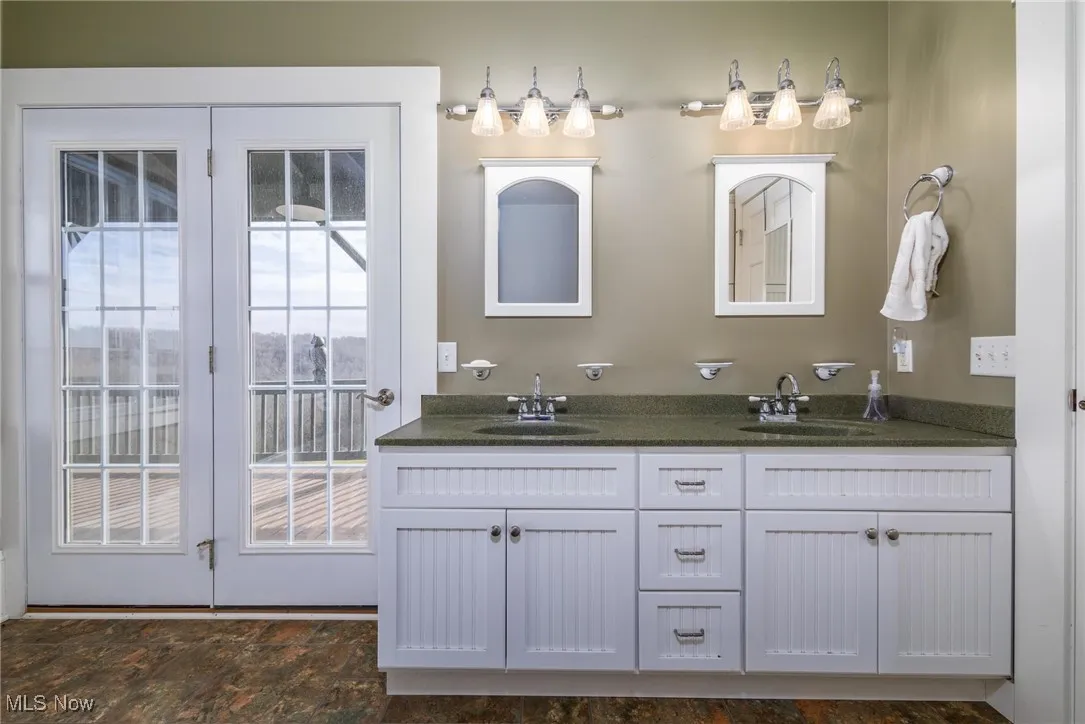Bathroom with dual vanity, plenty of natural light, and tile floors