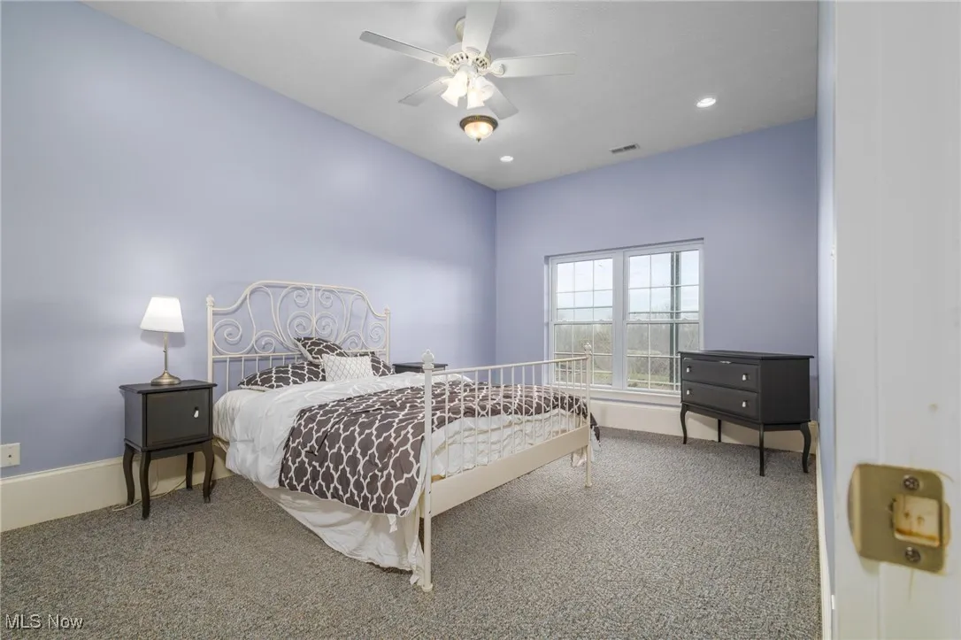 Bedroom with ceiling fan and carpet