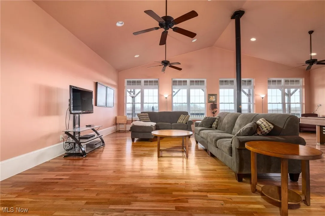 Living room with a wealth of natural light, light wood-type flooring, and ceiling fan