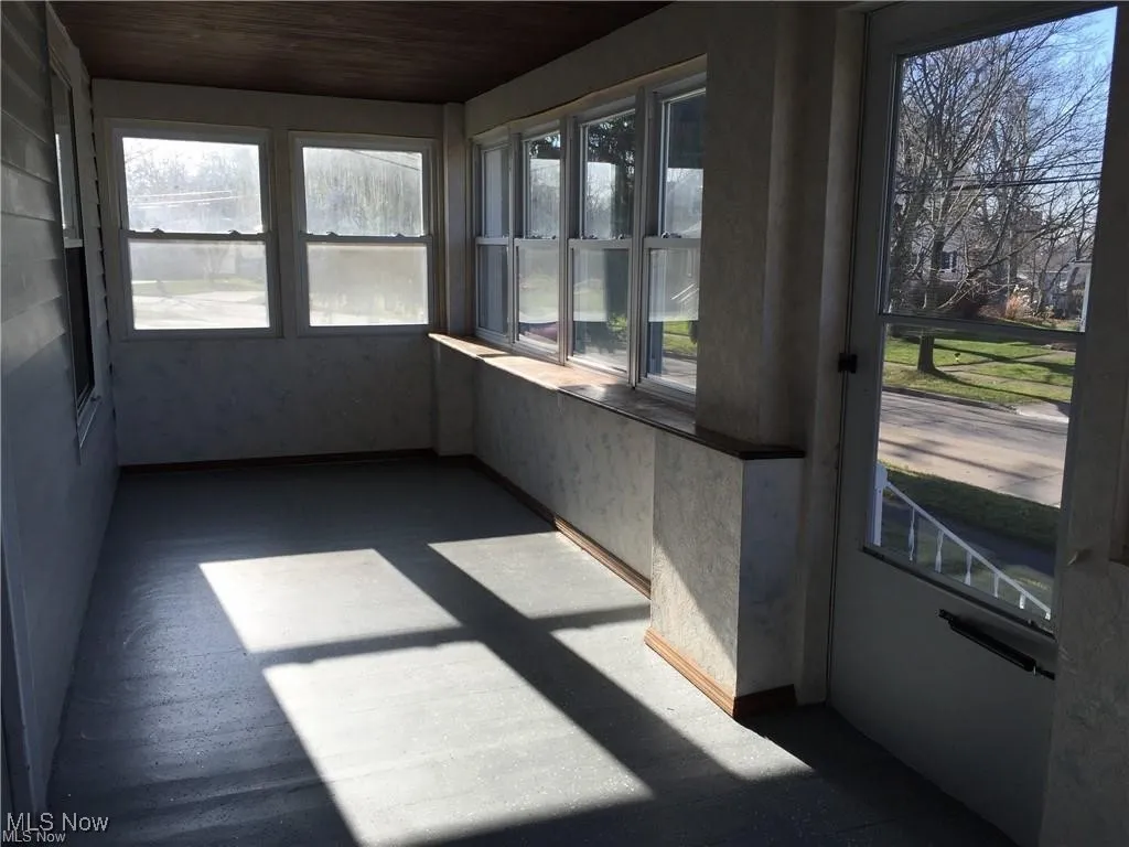 Unfurnished sunroom featuring wooden ceiling and a healthy amount of sunlight