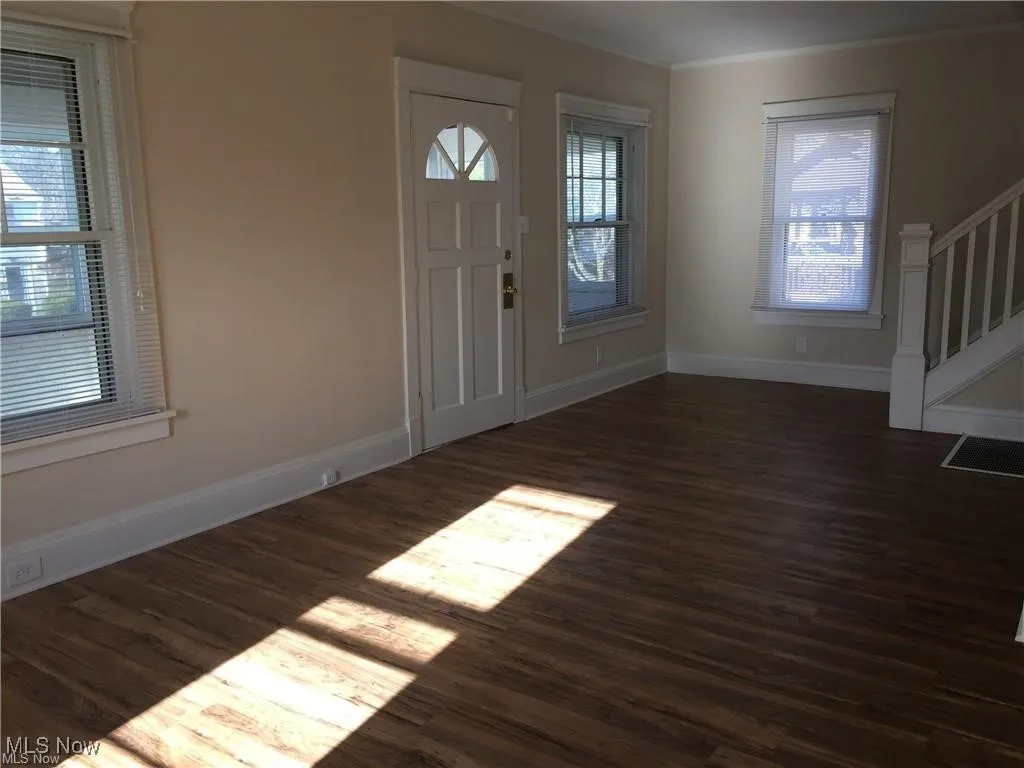 Entryway featuring crown molding, baseboards, stairs, and wood finished floors