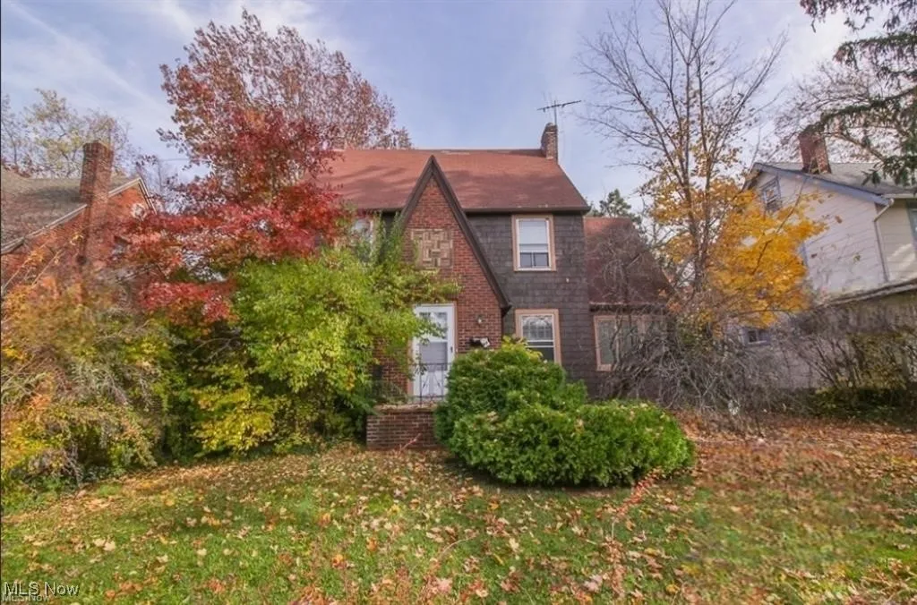 Tudor home with a front lawn and a chimney
