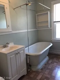 Full bath featuring a soaking tub and vanity