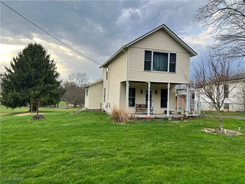 Traditional-style home featuring a front lawn and covered porch