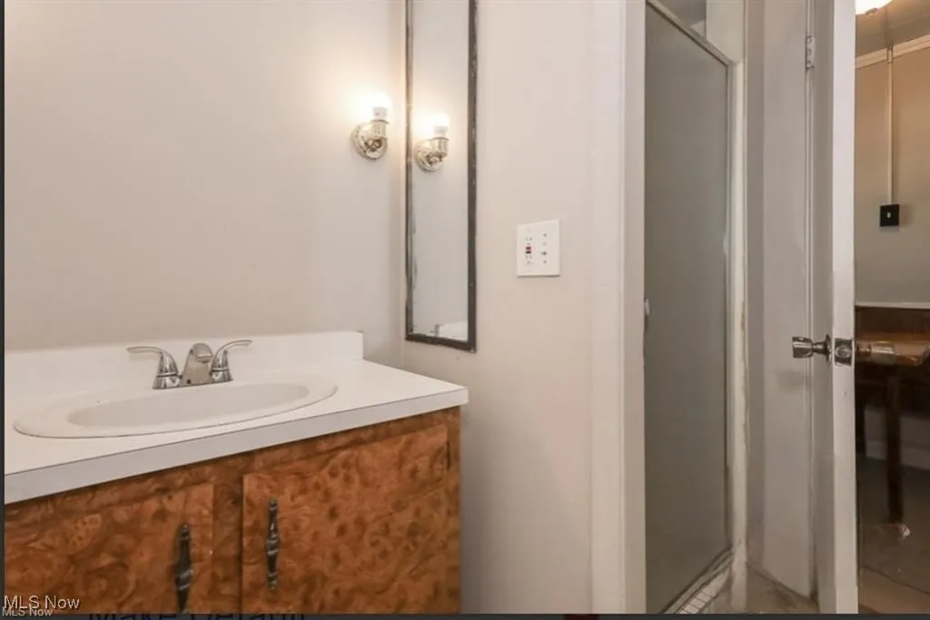 Bathroom featuring a shower with door and vanity