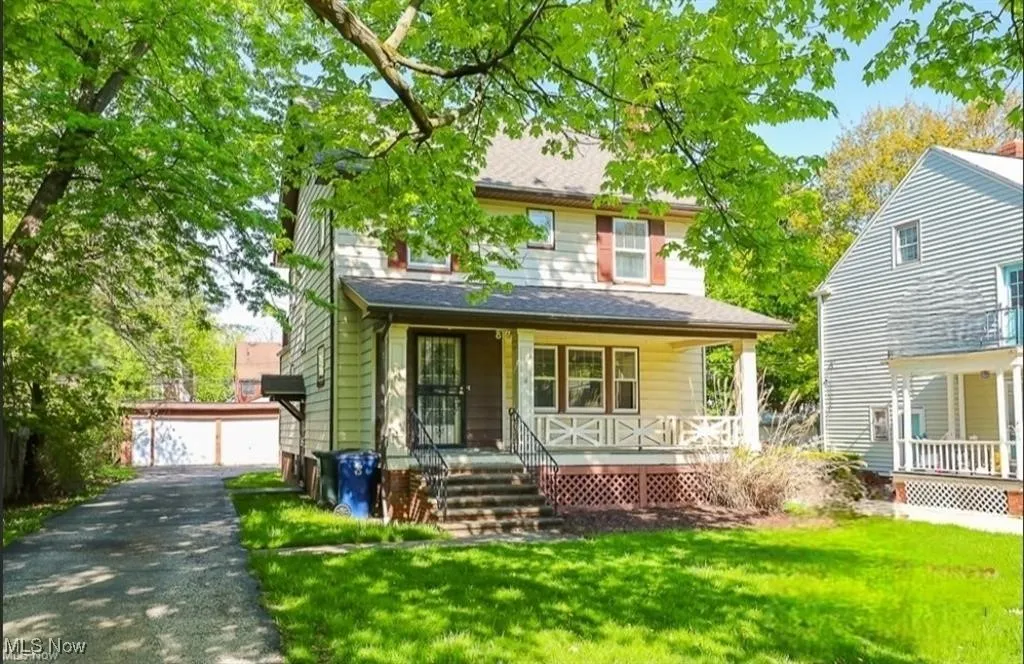 View of front facade featuring an outdoor structure, a porch, a garage, and a front lawn
