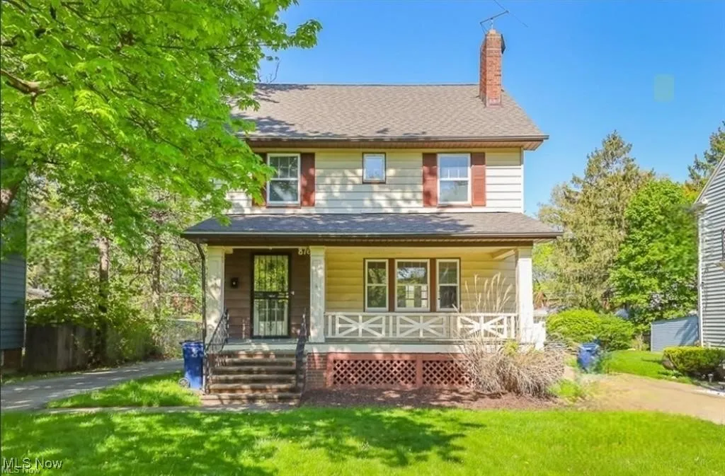 View of front of property featuring covered porch, a chimney, and a front yard