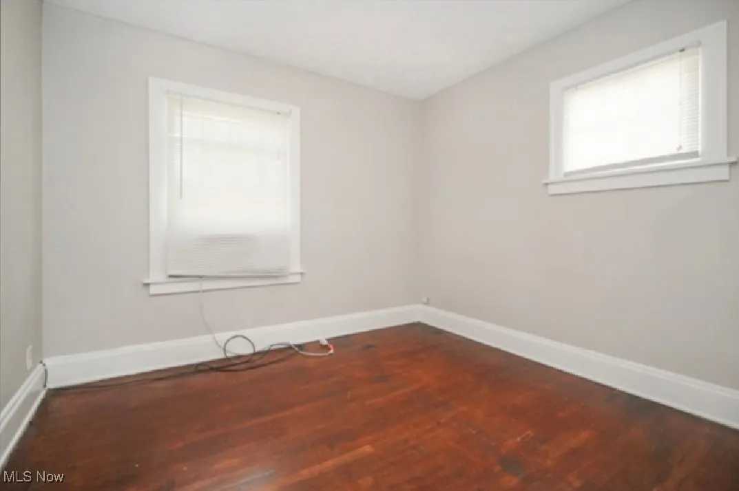 Spare room with baseboards and wood finished floors