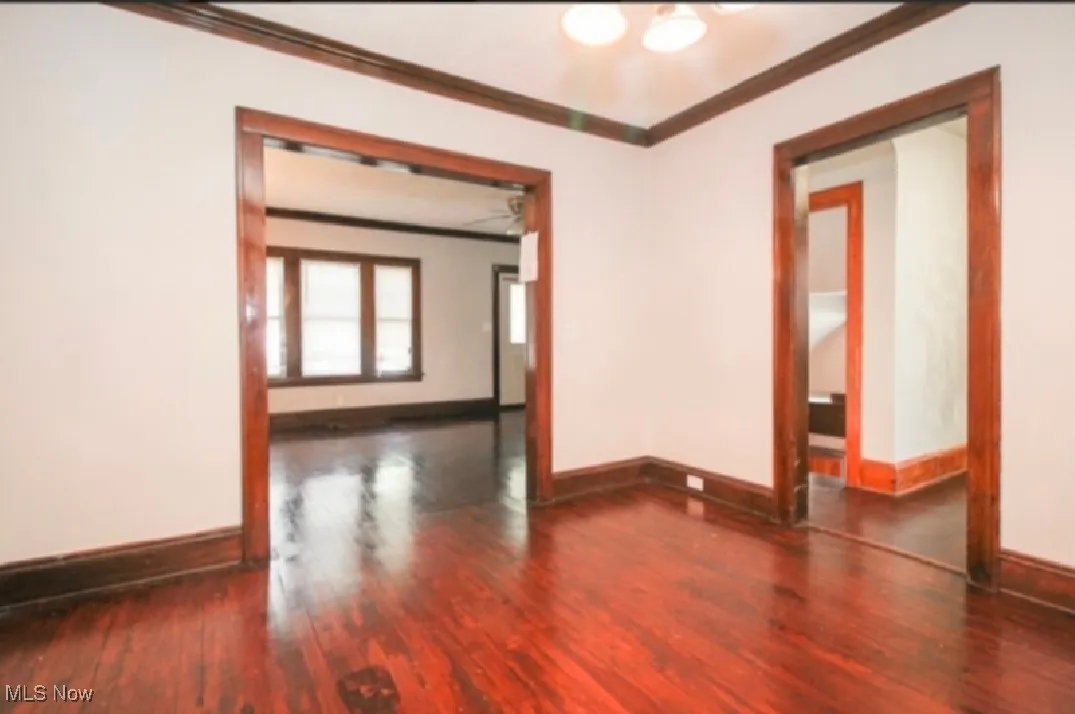 Spare room featuring ornamental molding, baseboards, and wood finished floors