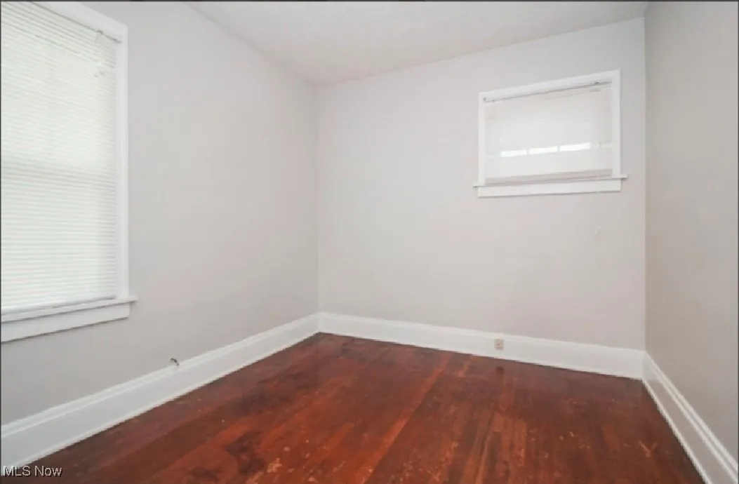 Spare room featuring baseboards and wood finished floors